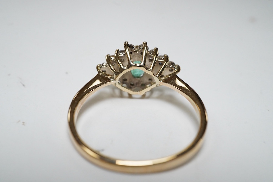 A yellow metal, emerald and diamond cluster set navette shaped ring, size P, gross weight 2.3 grams. Condition - fair to good